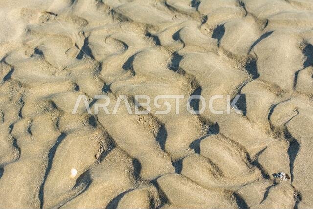 Pattern of small dunes at the beach after tide ebbing in corniche park, Dammam, Saudi Arabia
