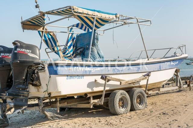 Fishing boat at the beach with background of sea in the corniche park, the city of Dammam, Kingdom of Saudi Arabia.