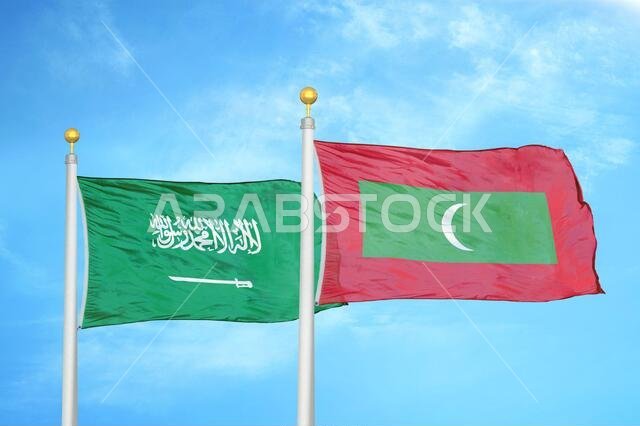 المملكة العربية السعودية وجزر المالديف، علمان على ساريتين وسماء زرقاء ملبدة بالغيوم