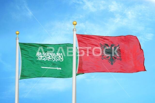 المملكة العربية السعودية وألبانيا، علمان على ساريتين وسماء زرقاء ملبدة بالغيوم