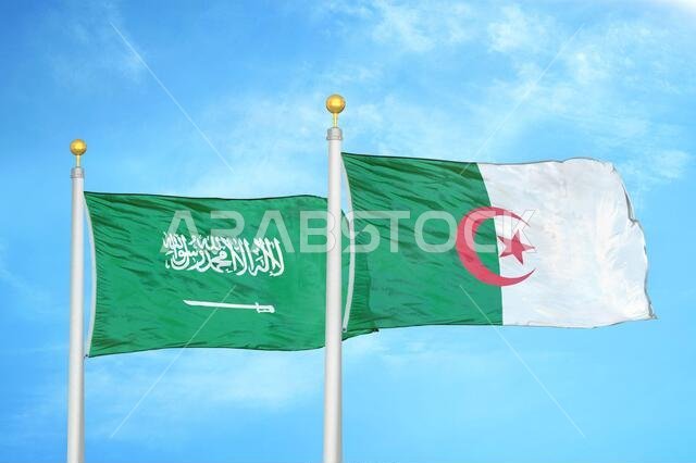 السعودية والجزائر، علمان على سارية علم، وسماء زرقاء ملبدة بالغيوم
