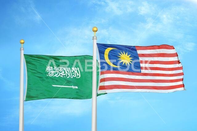 Saudi Arabia and Malaysia two flags on flagpoles and blue cloudy sky