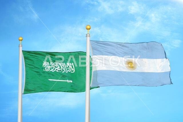 السعودية والأرجنتين، علمان على سارية علم، وسماء زرقاء ملبدة بالغيوم