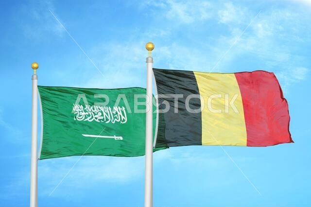 Saudi Arabia and Belgium two flags on flagpoles and blue cloudy sky