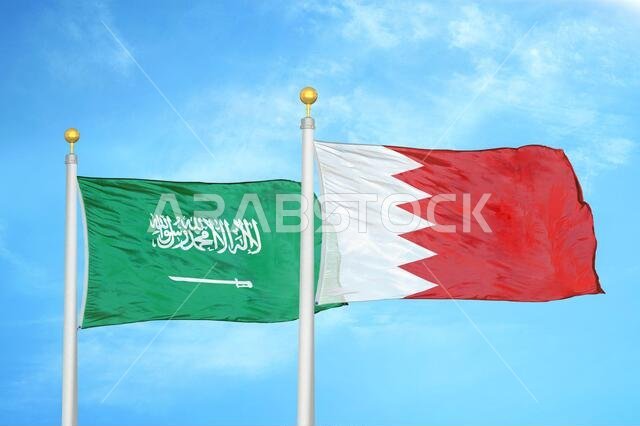 السعودية والبحرين، علمان على سارية علم، وسماء زرقاء ملبدة بالغيوم