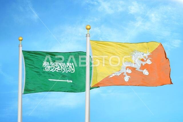 علمان للسعودية وبوتان على ساريتي علم وسماء زرقاء ملبدة بالغيوم