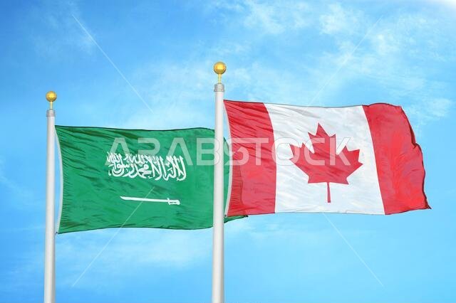 المملكة العربية السعودية وكندا، علمان على سارية علم، وسماء زرقاء ملبدة بالغيوم