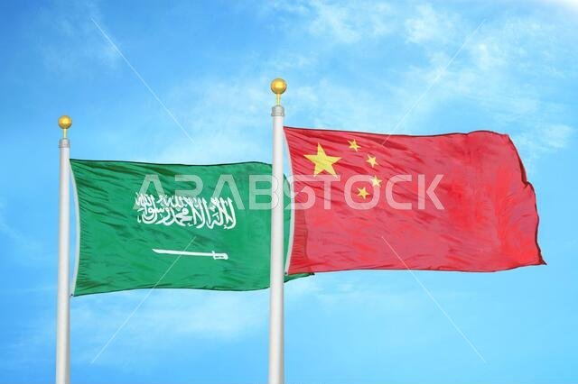 Saudi Arabia and China two flags on flagpoles and blue cloudy sky