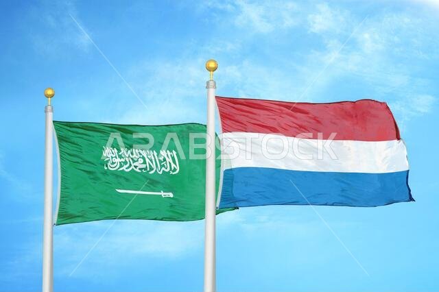 المملكة العربية السعودية وهولندا، علمان على سارية علم، وسماء زرقاء ملبدة بالغيوم