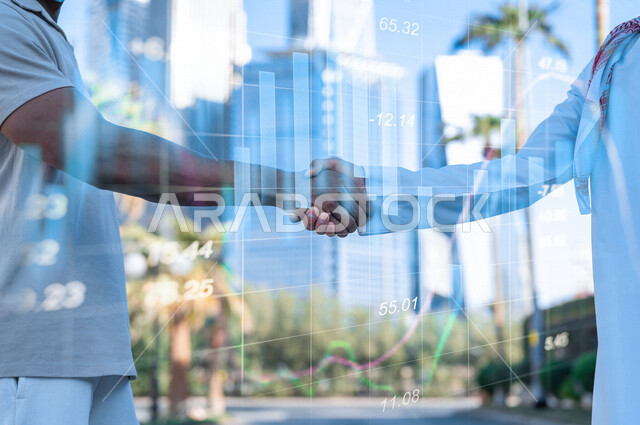 Two businessmen shake hands to complete a profitable deal, a business agreement, a project and a new business plan, business partners, progress and success, a Saudi company with high efficiency, hologram graphics.