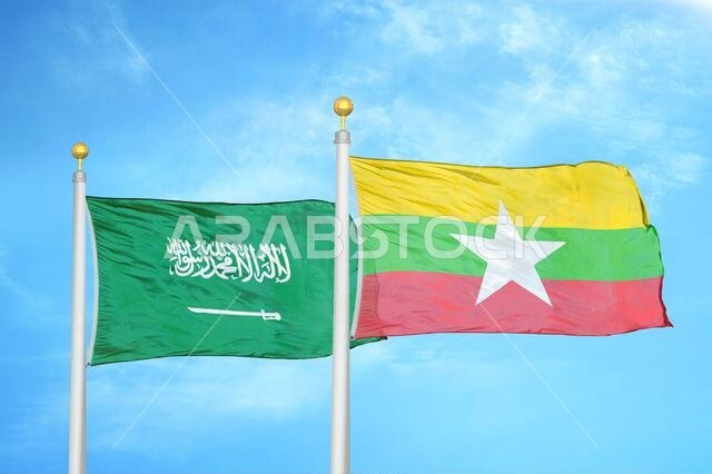 Saudi Arabia and Myanmar two flags on flagpoles and blue cloudy sky