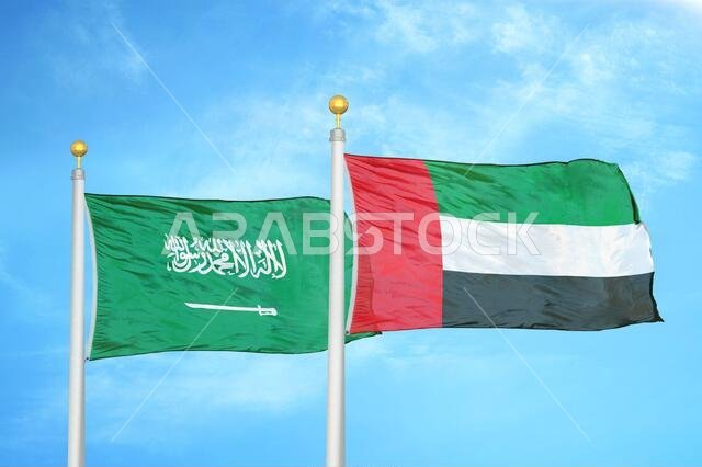 المملكة العربية السعودية والإمارات العربية المتحدة، علمان على ساريتين وسماء زرقاء ملبدة بالغيوم