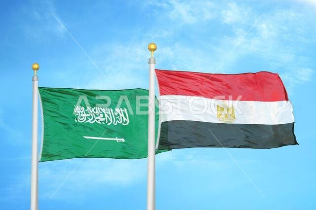 Saudi Arabia and Egypt two flags on flagpoles and blue cloudy sky
