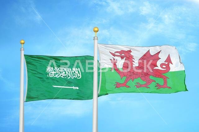 Saudi Arabia and Wales two flags on flagpoles and blue cloudy sky