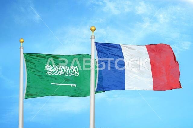 السعودية وفرنسا، علمان على سارية علم، وسماء زرقاء ملبدة بالغيوم