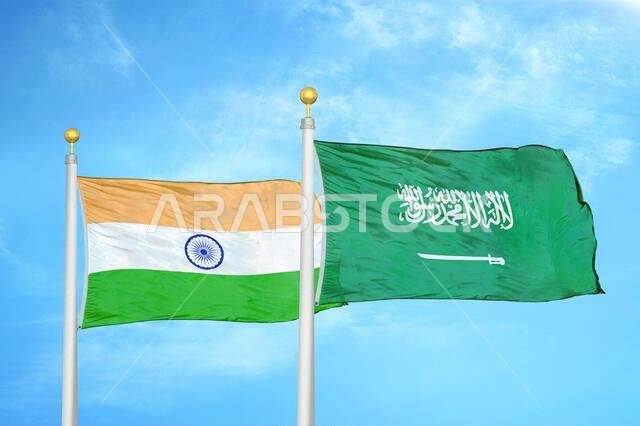 India and Saudi Arabia two flags on flagpoles and blue cloudy sky
