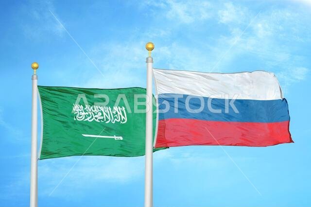Saudi Arabia and Russia two flags on flagpoles and blue cloudy sky