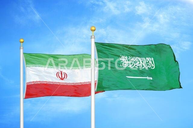 إيران والسعودية، علمان على سارية علم، وسماء زرقاء ملبدة بالغيوم