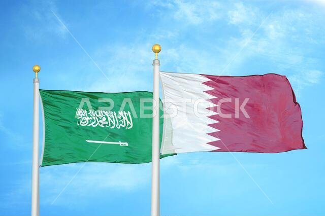 Saudi Arabia and Qatar two flags on flagpoles and blue cloudy sky