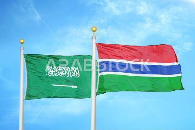 المملكة العربية السعودية وغامبيا، علمان على ساريتين وسماء زرقاء ملبدة بالغيوم