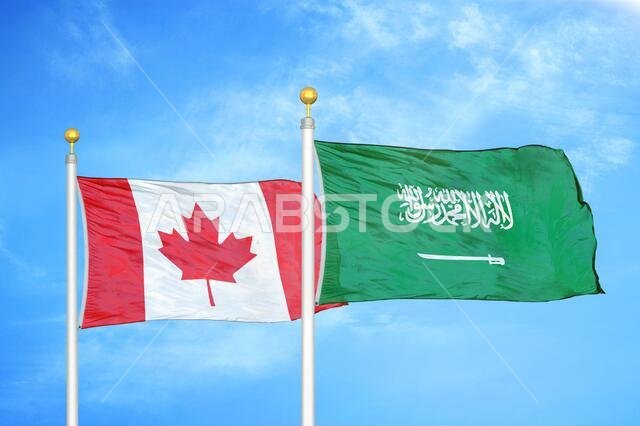 كندا والمملكة العربية السعودية، علمان على سارية علم، وسماء زرقاء ملبدة بالغيوم