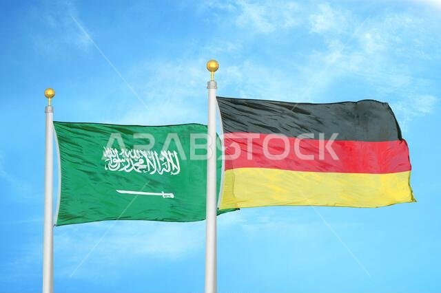 Saudi Arabia and Germany two flags on flagpoles and blue cloudy sky