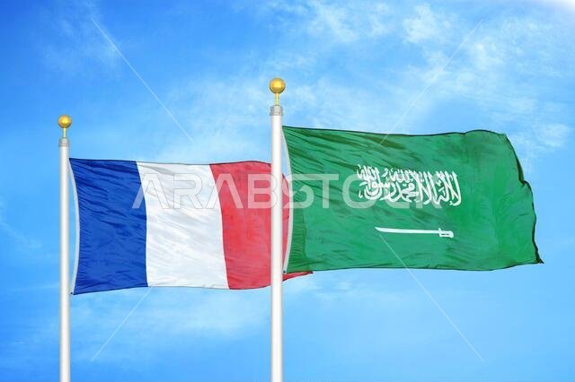 France and Saudi Arabia two flags on flagpoles and blue cloudy sky