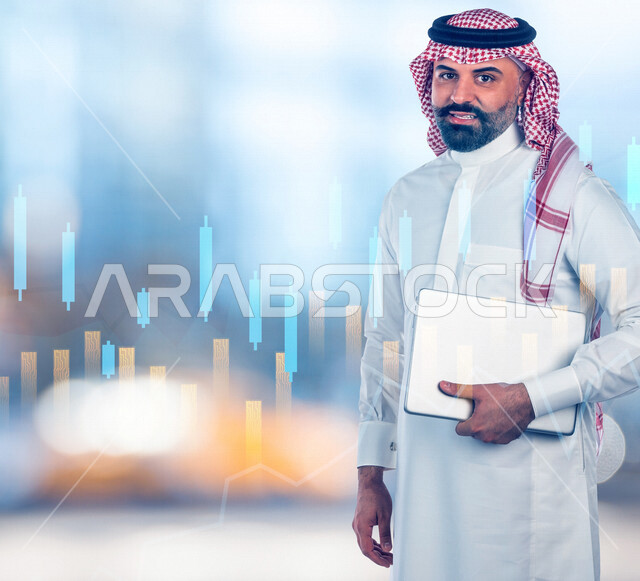 رجل عربي سعودي خليجي يحمل بيده جهاز الحاسوب، خلفية رسوم بيانية إحصائية للبورصة المالية بتقنية الهولوجرام ثلاثية الأبعاد، تطوير الشركات والمشاريع الاقتصادية، التجاره الإلكترونيه، متابعة الأسهم، الإستثمار المالي