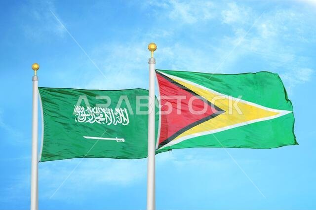 المملكة العربية السعودية وغيانا، علمان على سارية علم وسماء زرقاء ملبدة بالغيوم