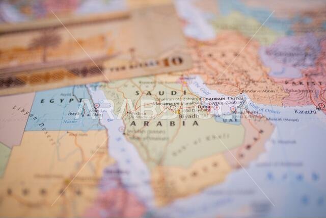 Ten riyals bill above Saudi Arabia on a colorful and blurry map of Western Asia