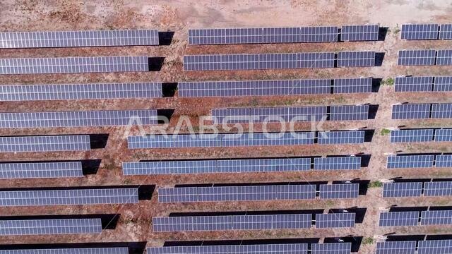 solar panels cell farm in aerial view. Alternative energy, ecology power conservation concept, during a sunny day on desert.