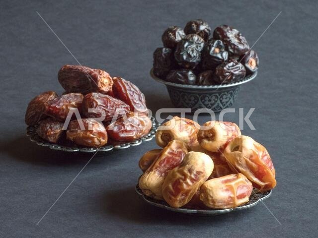 Arabic dates fruits are laid out on a dark table.