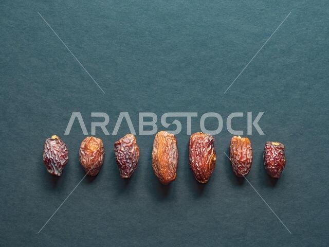 Medjool Al-Madina dates fruits are laid out on a dark table.