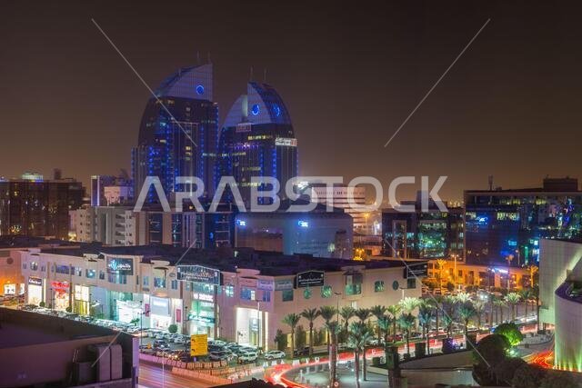 منظر جوي ليلي لمدينة الرياض مع أضواء النيون، ويظهر فيه مبنى بنك الإنماء التوأم في الرياض، المملكة العربية السعودية.