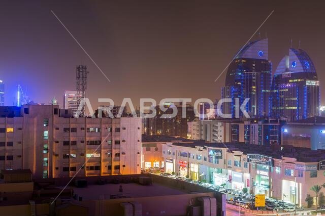 منظر جوي ليلي لمدينة الرياض مع أضواء النيون، ويظهر فيه مبنى بنك الإنماء التوأم في الرياض، المملكة العربية السعودية.
