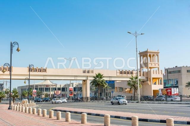 A footbridge with background of modern shopping mall  near the corniche park in Dammam city, Kingdom of Saudi Arabia