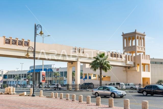 A footbridge with background of modern shopping mall  near the corniche park in Dammam city, Kingdom of Saudi Arabia