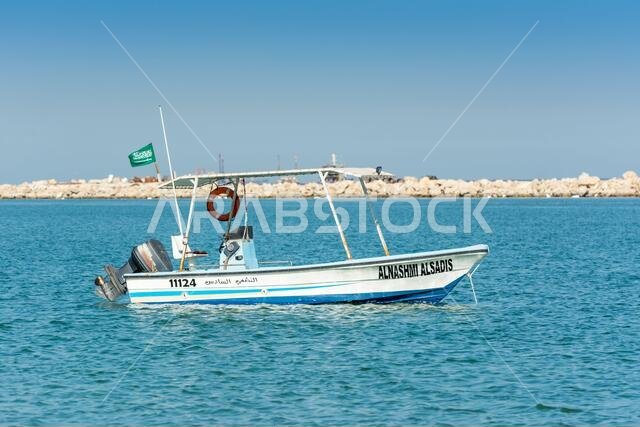 قارب صيد يطفو على البحر في حديقة الكورنيش، الدمام، المملكة العربية السعودية