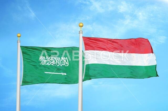 Saudi Arabia and Hungary two flags on flagpoles and blue cloudy sky