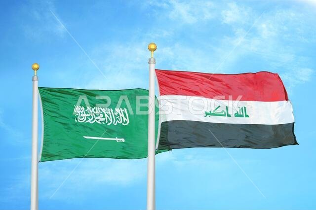 Saudi Arabia and Iraq two flags on flagpoles and blue cloudy sky