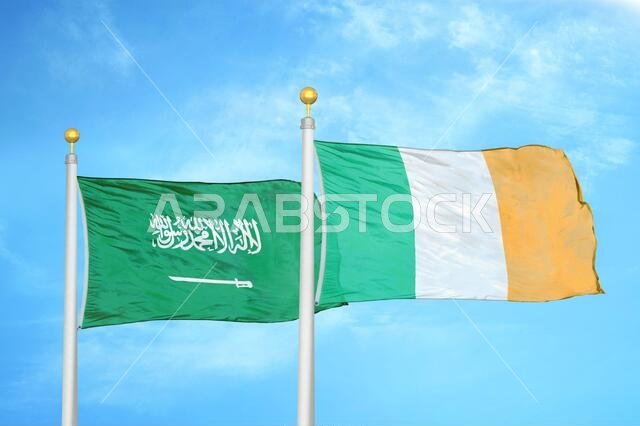 السعودية وأيرلندا، علمان على سارية علم، وسماء زرقاء ملبدة بالغيوم