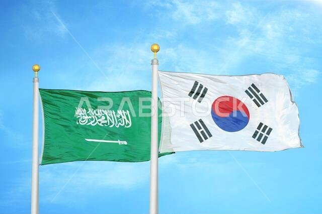 Saudi Arabia and South Korea two flags on flagpoles and blue cloudy sky