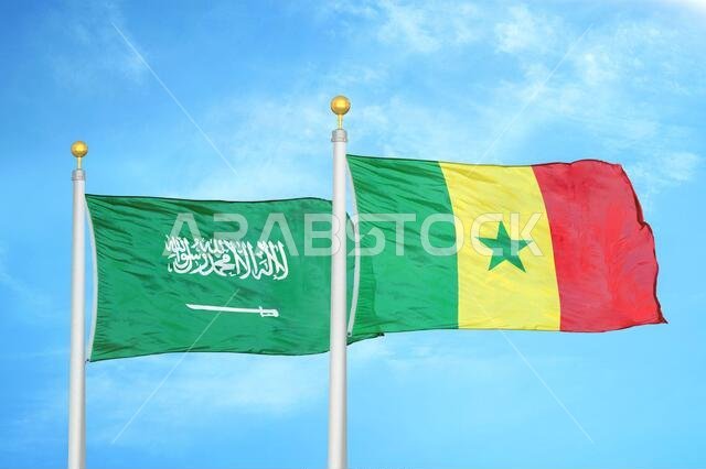 Saudi Arabia and Senegal two flags on flagpoles and blue cloudy sky