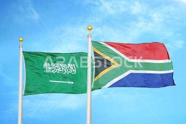 Saudi Arabia and South Africa two flags on flagpoles and blue cloudy sky