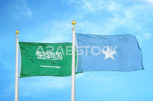 Saudi Arabia and Somalia two flags on flagpoles and blue cloudy sky