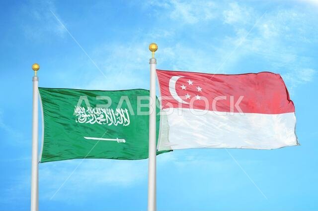 المملكة العربية السعودية وسنغافورة، علمان على سارية العلم، وسماء زرقاء ملبدة بالغيوم