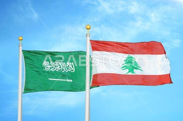 السعودية ولبنان، علمان على سارية علم، وسماء زرقاء ملبدة بالغيوم