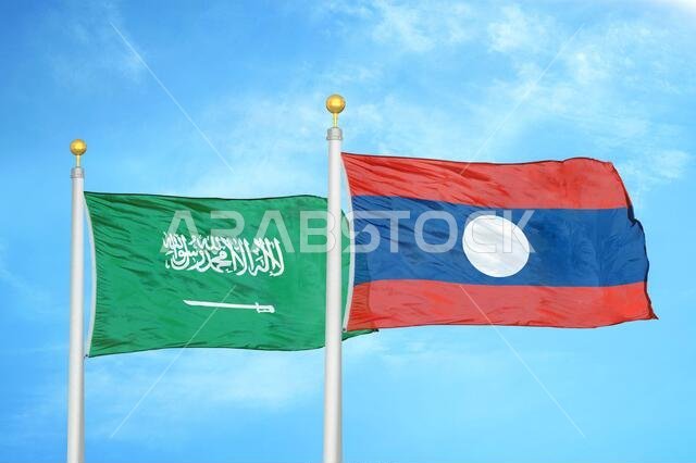 Saudi Arabia and Laos. two flags on flagpoles and blue cloudy sky