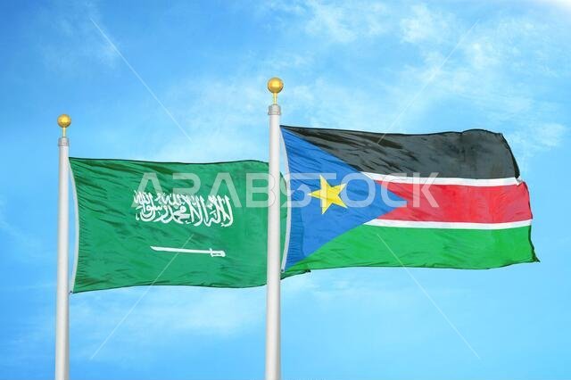 Saudi Arabia and South Sudan two flags on flagpoles and blue cloudy sky