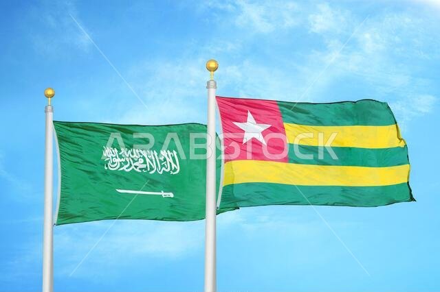 السعودية وتوغو، علمان على سارية علم، وسماء زرقاء ملبدة بالغيوم